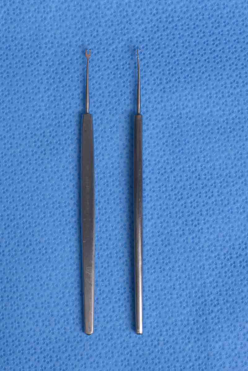 This small, double-pronged hook is used for holding and retracting the edges of skin during surgery.  This skin hook of choice for retracting eyelid skin prevents crushing that would otherwise be caused by the use of forceps.